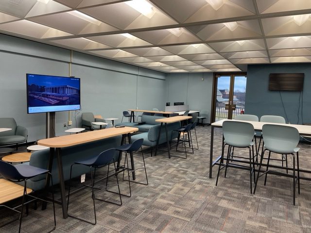 The data visualization lab showing numerous of types of seating including high top tables and comfortable couch like seating with desktops.