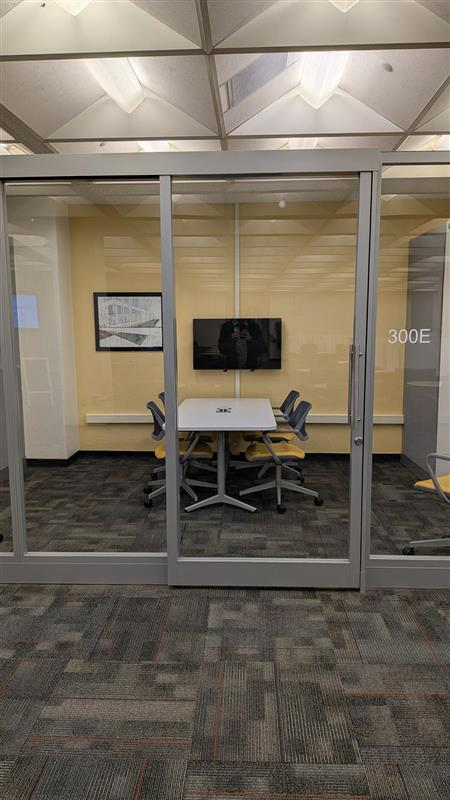 Group study room with table, chairs, and tv.
