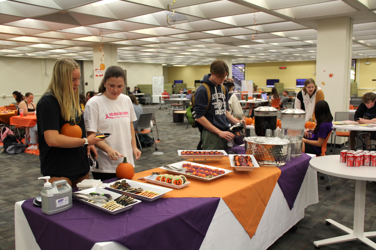 Students selecting desserts to eat at Halloween event in the Learning Commons.