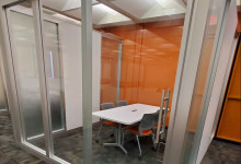 4th floor group study space featuring a table with chairs surrounded by glass walls