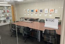 2-112C reservable room in Gunnin library with group meeting space includes a large monitor display and table with chairs.