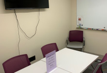 small study space with a desk and 5 chairs with wall mounted display