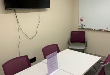 small study space with a desk and 5 chairs with wall mounted display