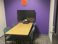 interview room with a desk, four chairs and a display